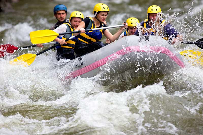 Group of people whitewater rafting down the French Broad river in NC